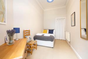 a small bedroom with a bed and a desk at ALTIDO 3-bed Meadows flat near Castle in Edinburgh