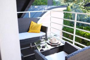 einen Balkon mit Stühlen und einem Tisch mit gelbem Kissen in der Unterkunft The Modern & Comfortable Apartment in Ljubljana