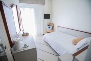 ein weißes Schlafzimmer mit einem Bett und einem Fenster in der Unterkunft Hotel Gambrinus - Valentini Family Village in Bellaria-Igea Marina