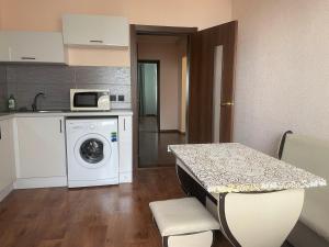 a small kitchen with a washing machine and a table at Квартира в новому будинку in Kyiv