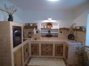 a large kitchen with wooden cabinets and a stove at ETNO HOUSE GOSTECE- Suite with Finnish sauna in Mozirje