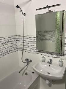 a white bathroom with a sink and a mirror at Квартира в новому будинку in Kyiv