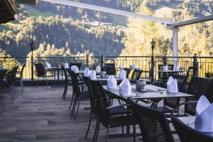 a restaurant with tables and chairs with mountains in the background at die Aussicht in Finkenberg