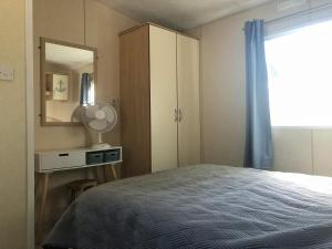 a bedroom with a bed with a mirror and a dresser at CoCo Beach House op Recreatiepark De Wielen in Sint Maarten +27 photos