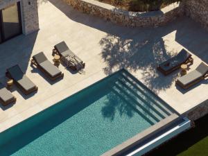 an overhead view of a swimming pool with chaise lounge chairs and a swimming pool at Veda Villa in Agios Nikolaos