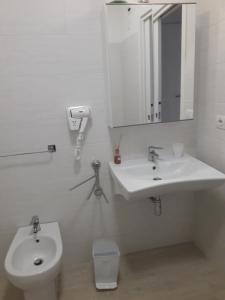 uma casa de banho branca com um lavatório e um WC em Corso95 SrL em Iesi