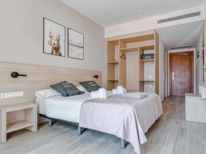 una camera con 2 letti e un pavimento in legno di limehome Barcelona Carrer de Besalú 82 a Barcellona