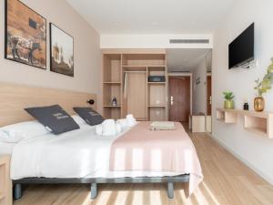 1 dormitorio con 1 cama blanca grande con almohadas blancas en limehome Barcelona Carrer de Besalú 82 en Barcelona