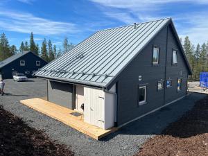 a black house with a garage on a lot at New cabin in fabulous Idre activity area in Idre