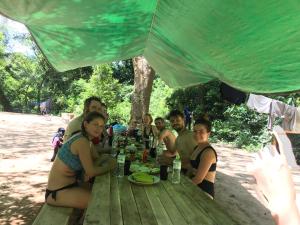 un grupo de personas sentadas en una mesa de picnic en BeHome HomeStay, en Phong Nha
