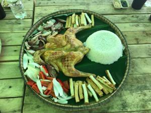 un plato de comida con verduras y arroz en una mesa en BeHome HomeStay, en Phong Nha