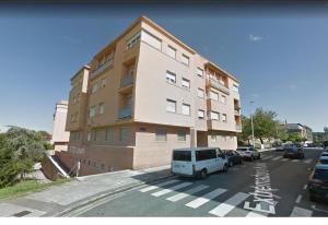 uma carrinha branca estacionada em frente a um edifício em Apartamento en San Sebastián con parking em Loyola