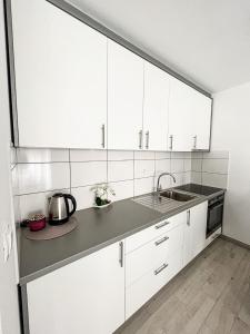 a kitchen with white cabinets and a sink at Apartment Doris in Tomislavgrad