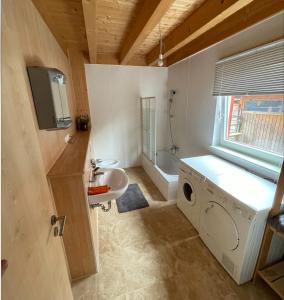een badkamer met een wastafel en een wasmachine bij Ferienhaus Stefanie in Bernbeuren
