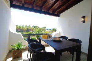 una sala da pranzo con tavolo e sedie sul balcone di Sao Rafael Beach Apartment - By Dalma Portuguesa ad Albufeira