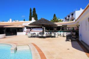 a resort with a swimming pool and tables and chairs at Sao Rafael Beach Apartment - By Dalma Portuguesa in Albufeira