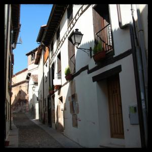 un callejón con edificios blancos y un semáforo en Hotel Rural Princesa Kristina, en Covarrubias