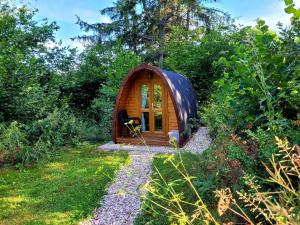 eine kleine Holzhütte inmitten eines Gartens in der Unterkunft PODs Alte Schule in Elchweiler