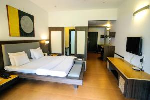 a bedroom with a large bed and a television at Treasure Island Resorts Lonavala in Lonavala