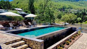 a swimming pool with a stone wall around it at Dedehan Retreat Otel in Muğla