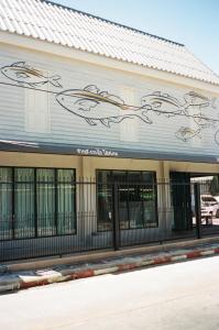 un bâtiment avec une fresque murale représentant des poissons sur son côté dans l'établissement Tali-Yailai Hostel, à Pattaya