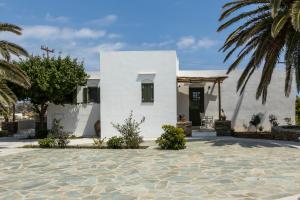 a white house with palm trees in front of it at ANCIENT MEROPIA - Eden in Apollonia