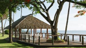 a pavilion with chairs and a table on the beach at Holiday Inn Suva, an IHG Hotel in Suva