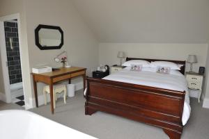 a bedroom with a bed and a desk and a mirror at Suenos Guesthouse in Southend-on-Sea