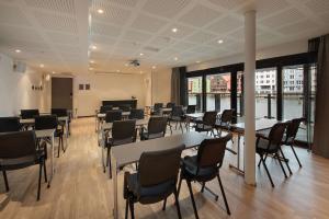 une salle de réunion avec des tables et des chaises dans un bâtiment dans l'établissement Scandic Bakklandet, à Trondheim