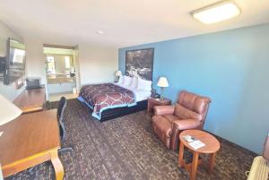 Pokój hotelowy z łóżkiem i krzesłem w obiekcie Super 8 by Wyndham McGehee w mieście McGehee