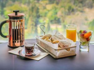 a table with two baskets of bread and a cup of coffee at Pullman Santiago Vitacura in Santiago