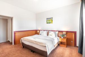 a bedroom with a bed and a dresser at Novum Hotel Aldea Berlin Centrum in Berlin