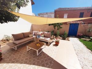 Eine Frau auf einer Couch auf einer Terrasse in der Unterkunft Albergue Villares de Orbigo in Villares de Órbigo