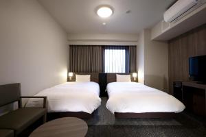 Voodi või voodid majutusasutuse Dormy Inn Okayama Natural Hot Spring toas