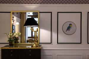 een kamer met een spiegel en een tafel met een lamp bij IL Tornabuoni The Unbound Collection by Hyatt in Florence