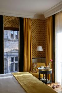 a bedroom with a bed and a table and a window at IL Tornabuoni The Unbound Collection by Hyatt in Florence