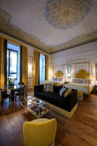 a living room with a bed and a couch and a table at IL Tornabuoni The Unbound Collection by Hyatt in Florence