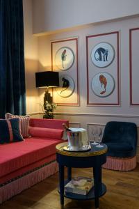 a living room with a red couch and a table at IL Tornabuoni The Unbound Collection by Hyatt in Florence