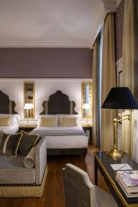 a hotel room with two beds and a couch at IL Tornabuoni The Unbound Collection by Hyatt in Florence