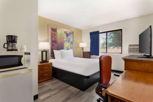 a hotel room with a bed and a microwave at Baymont by Wyndham Hutchinson in Hutchinson