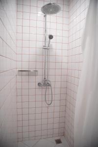 a shower in a white tiled bathroom at Tali-Yailai Hostel in Pattaya