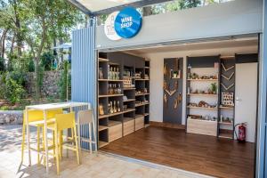 a shop with a table and yellow stools at Valamar Camping Ježevac in Krk