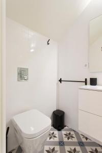 ein Badezimmer mit einem weißen WC und einem schwarz-weißen Fliesenboden in der Unterkunft Zen Garden Studio D in Porto
