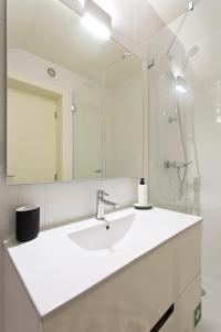 ein weißes Badezimmer mit einem Waschbecken und einem Spiegel in der Unterkunft Zen Garden Studio D in Porto