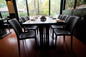 a dining room table with chairs and a large window at Treasure Island Resorts Lonavala in Lonavala