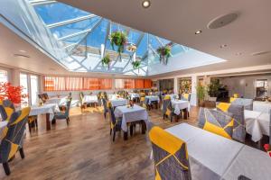 een restaurant met tafels en stoelen en een groot dakraam bij Saints Bay Hotel in St Martin Guernsey