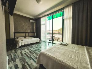 a bedroom with two beds and a large window at Discovery Hotel in Kutaisi