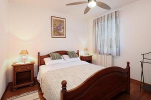 a bedroom with a bed and a ceiling fan at Apartman Villa Marina in Rakalj