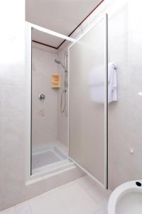 a shower with a glass door in a bathroom at Apartman Villa Marina in Rakalj