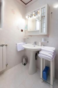 a white bathroom with a sink and a mirror at Apartman Villa Marina in Rakalj
